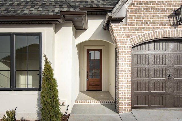 property entrance featuring stucco siding, brick siding, and a shingled roof