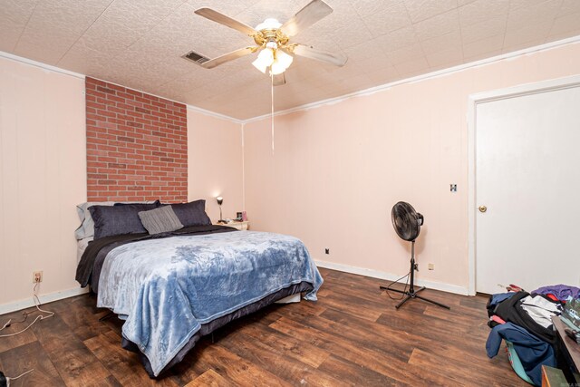 bedroom featuring ceiling fan, wood finished floors, visible vents, and ornamental molding