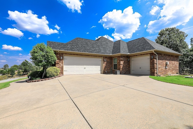 view of front of house with a garage, brick siding, and roof with shingles