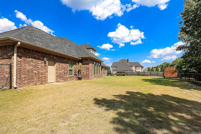 view of yard featuring an outbuilding, fence private yard, and a storage shed