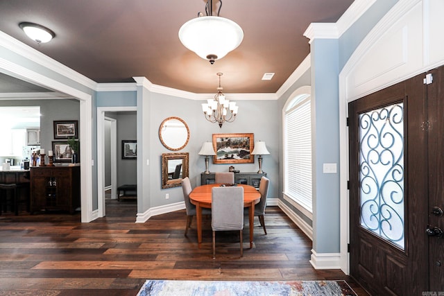 dining area with dark wood-type flooring, a notable chandelier, crown molding, and baseboards