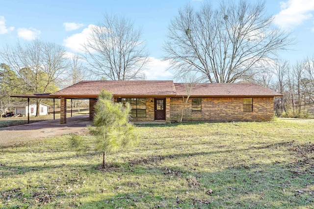 view of front of property featuring brick siding, an attached carport, driveway, and a front lawn