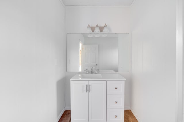 bathroom featuring baseboards, wood finished floors, and vanity