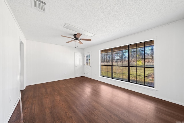 spare room with visible vents, a textured ceiling, dark wood-style floors, and a ceiling fan