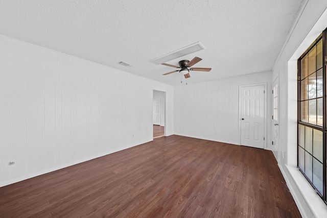 empty room with visible vents, a textured ceiling, a ceiling fan, and wood finished floors