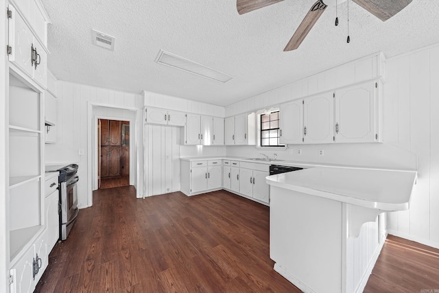 kitchen featuring stainless steel range with electric stovetop, a ceiling fan, dark wood finished floors, a peninsula, and white cabinets