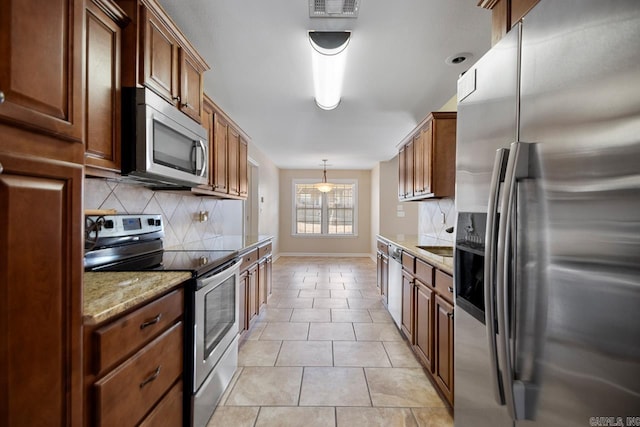 kitchen featuring visible vents, light stone counters, backsplash, appliances with stainless steel finishes, and light tile patterned floors