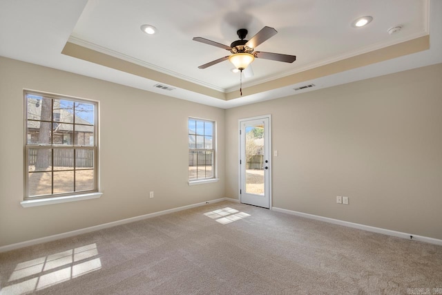 unfurnished room featuring a tray ceiling, visible vents, and ornamental molding