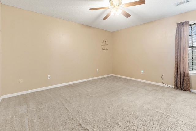 carpeted empty room featuring a textured ceiling, baseboards, visible vents, and ceiling fan