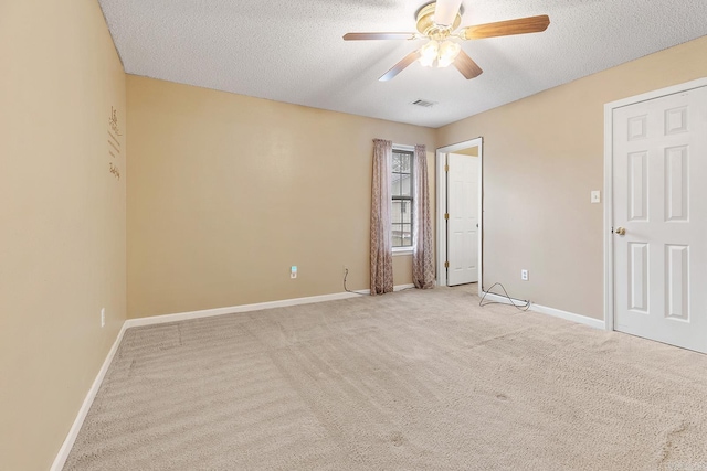 unfurnished room featuring light carpet, visible vents, a textured ceiling, and baseboards