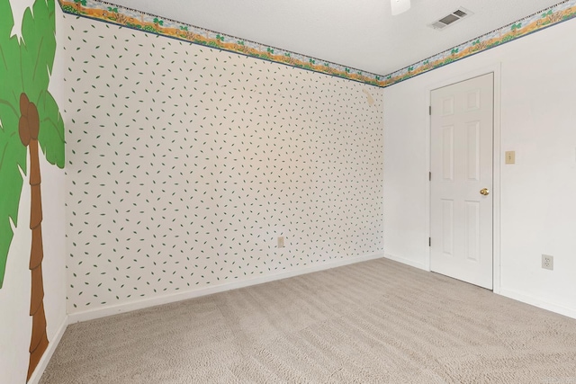 unfurnished room with visible vents, baseboards, and carpet floors