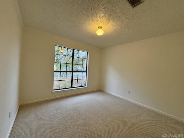 carpeted empty room featuring baseboards, visible vents, and a textured ceiling