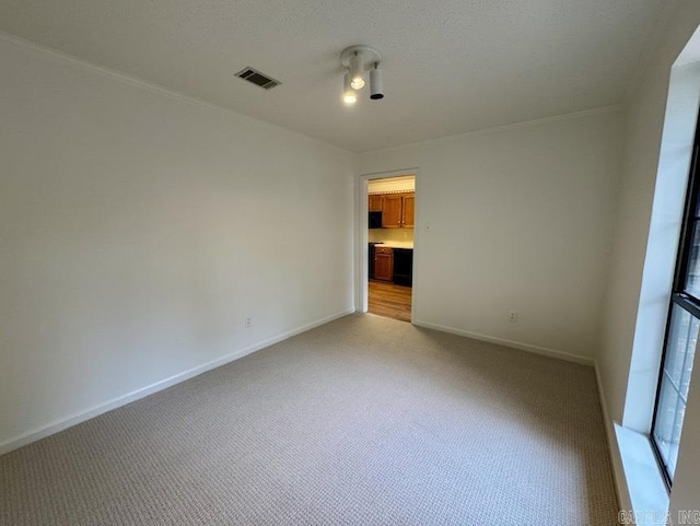 spare room with light carpet, visible vents, and baseboards