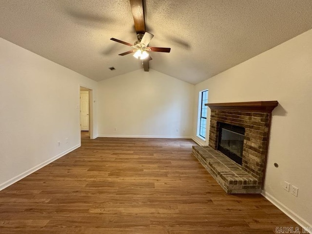 unfurnished living room featuring baseboards, lofted ceiling, wood finished floors, and a fireplace