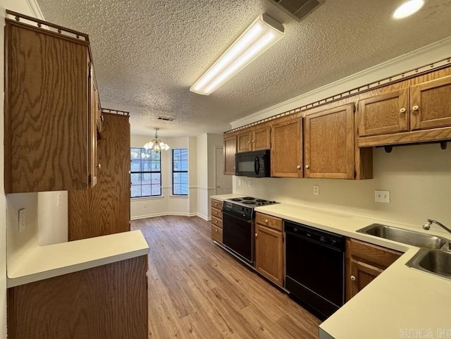 kitchen featuring black appliances, brown cabinetry, wood finished floors, and light countertops