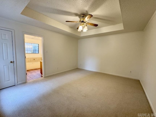 unfurnished bedroom featuring a textured ceiling and a tray ceiling