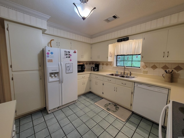 kitchen featuring a sink, white appliances, tasteful backsplash, and ornamental molding