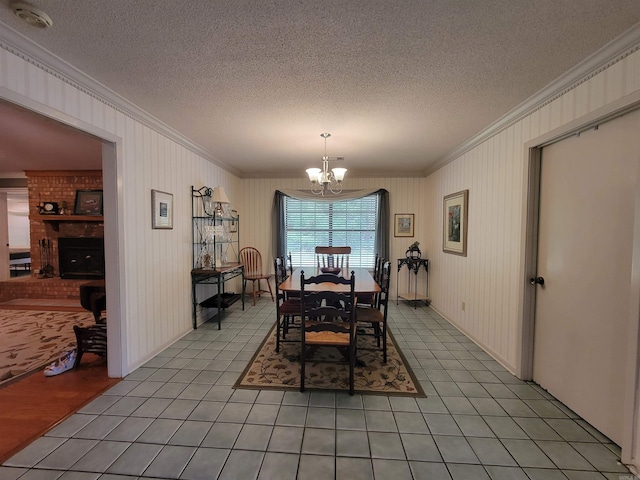 dining room with light tile patterned floors, a textured ceiling, an inviting chandelier, and ornamental molding