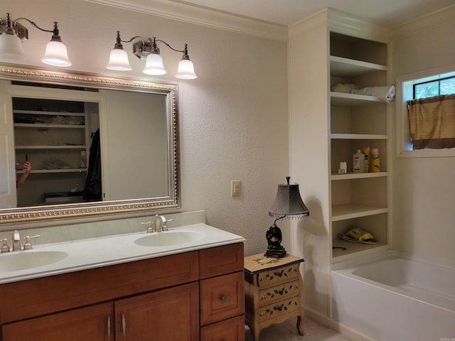 full bathroom with a sink, a spacious closet, ornamental molding, and double vanity