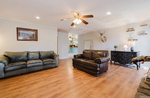 living room with light wood-style flooring, recessed lighting, a ceiling fan, and ornamental molding