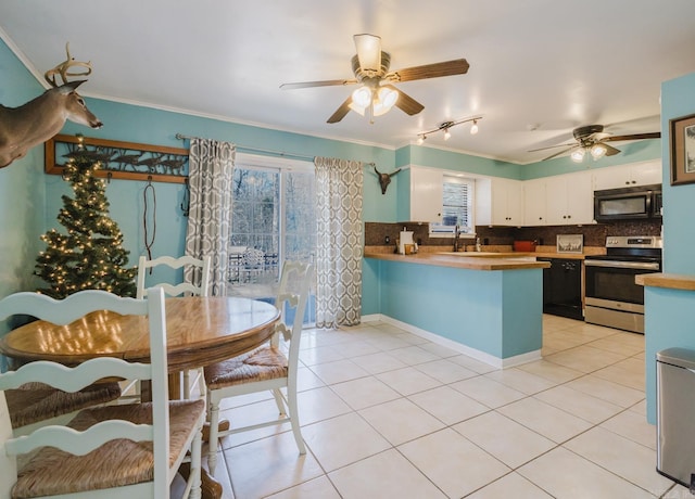 kitchen with crown molding, black microwave, light tile patterned floors, a peninsula, and electric range