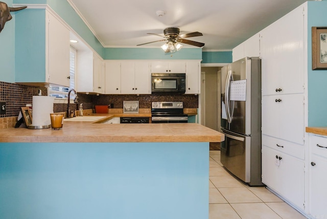 kitchen with a sink, stainless steel appliances, a peninsula, light tile patterned floors, and decorative backsplash