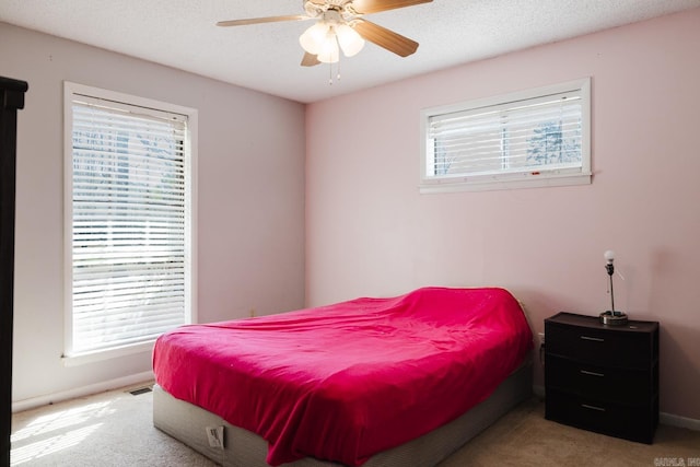 bedroom featuring visible vents, baseboards, a textured ceiling, and carpet