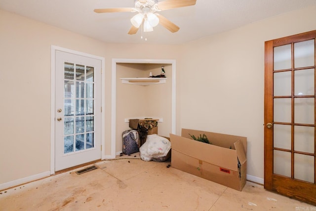 doorway with a ceiling fan, visible vents, and baseboards