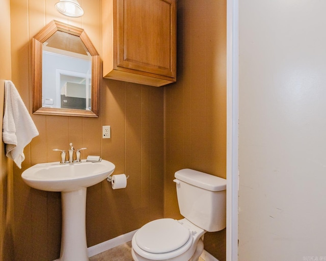 bathroom with a sink, baseboards, and toilet