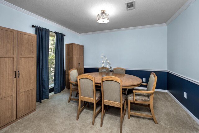 dining room with visible vents, light colored carpet, crown molding, and a textured ceiling
