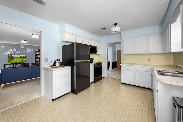 kitchen featuring white cabinetry, black appliances, light countertops, and visible vents