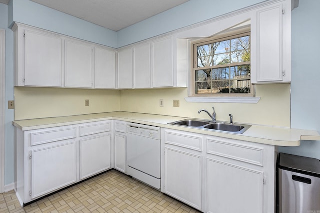 kitchen featuring a sink, white cabinets, light countertops, and white dishwasher