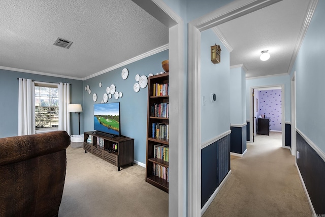 hall with visible vents, light colored carpet, a textured ceiling, and crown molding