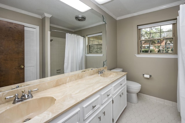 full bath featuring a sink, baseboards, crown molding, and tile patterned flooring