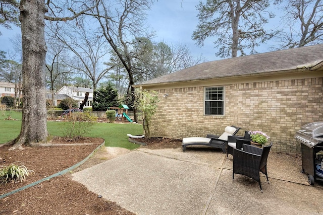 view of patio featuring a grill, a playground, and fence