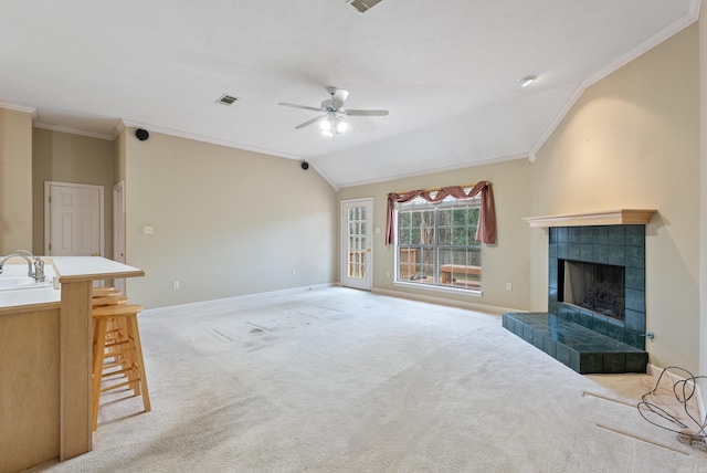 unfurnished living room with ornamental molding, a fireplace, baseboards, light colored carpet, and vaulted ceiling