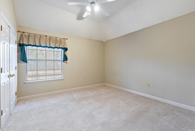 unfurnished room with lofted ceiling, a ceiling fan, baseboards, and light carpet