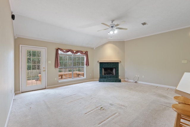 unfurnished living room with baseboards, a tile fireplace, vaulted ceiling, crown molding, and carpet flooring