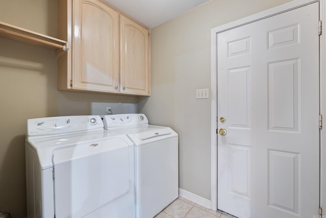 clothes washing area with baseboards, cabinet space, separate washer and dryer, and light tile patterned flooring