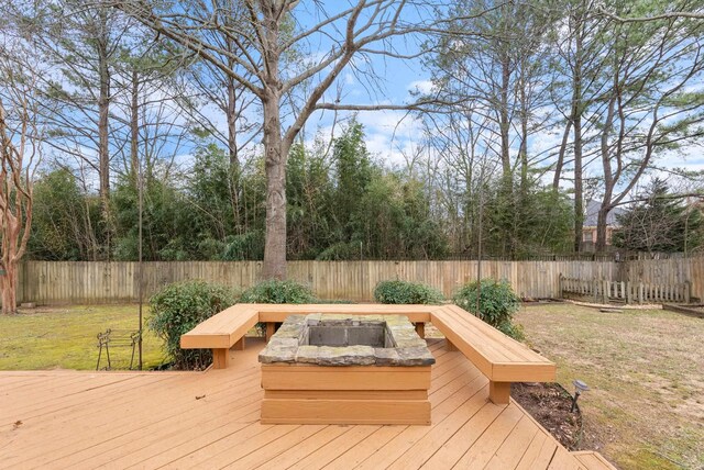 wooden terrace featuring a yard, a fire pit, and a fenced backyard