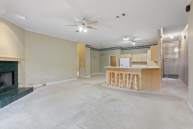 unfurnished living room with crown molding, light carpet, visible vents, and a tile fireplace