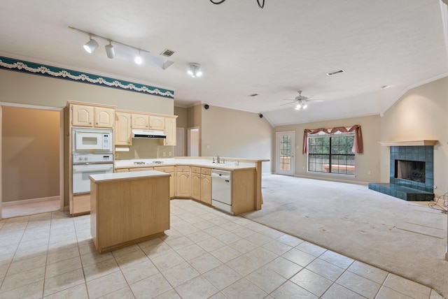 kitchen featuring white appliances, light brown cabinets, light colored carpet, and visible vents