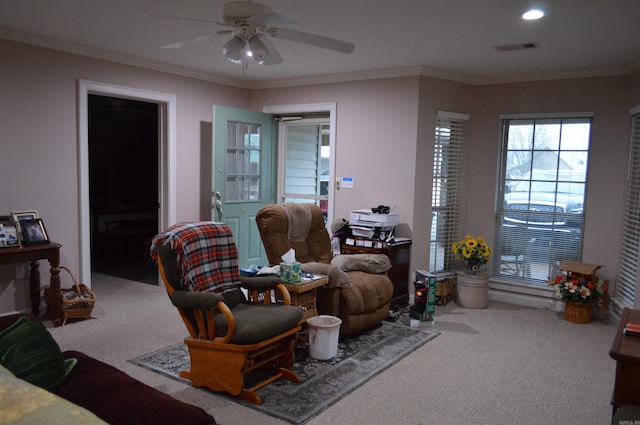 sitting room with visible vents, a ceiling fan, crown molding, and carpet