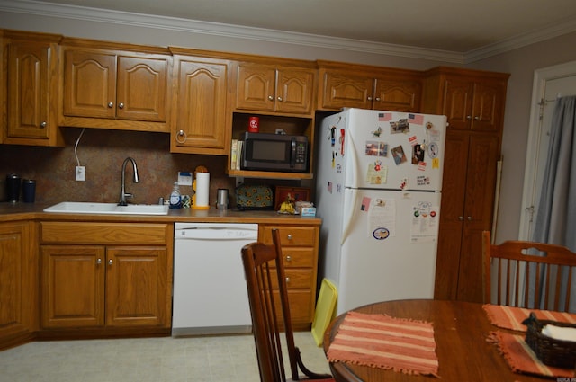 kitchen featuring backsplash, crown molding, brown cabinetry, white appliances, and a sink