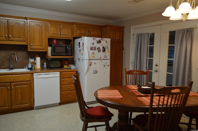 kitchen featuring ornamental molding, french doors, brown cabinetry, white appliances, and a sink