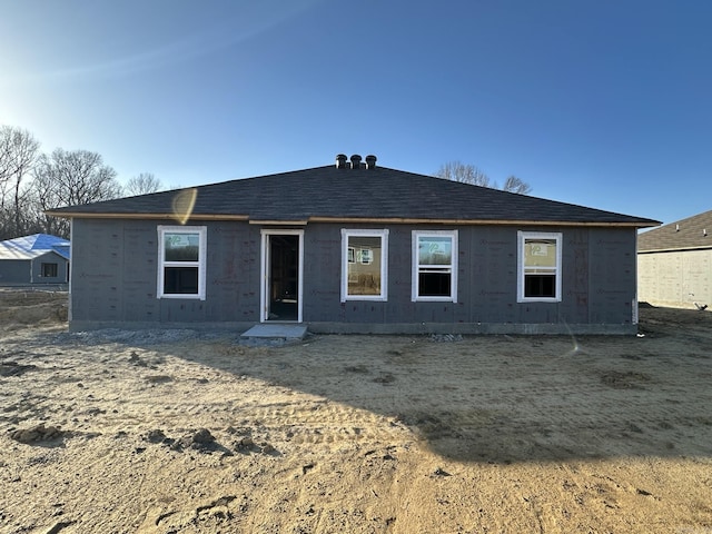 back of house with roof with shingles