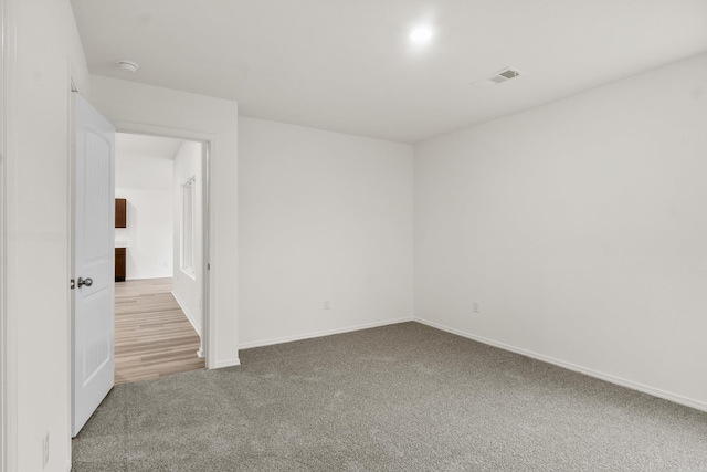 empty room with carpet flooring, baseboards, and a smoke detector
