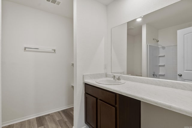 full bath featuring wood finished floors, vanity, and baseboards