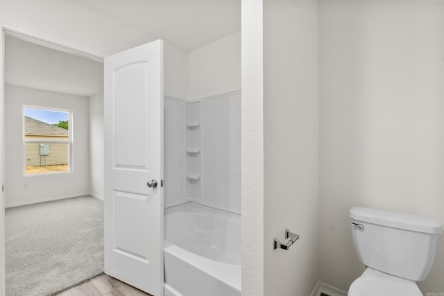 bathroom with toilet, baseboards, and wood finished floors