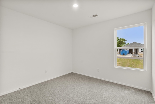 carpeted empty room featuring baseboards
